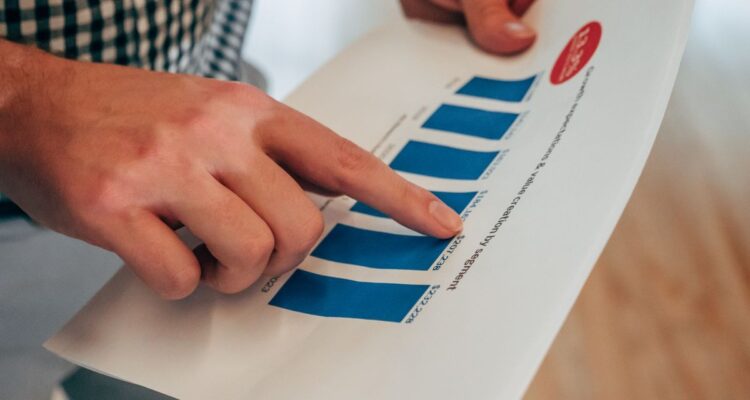 Hands pointing at a printed bar chart titled growth expectations and value creation by segment
